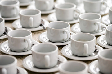 Fototapeta na wymiar a lot of rows of pure white cups with plates for coffee or tea break