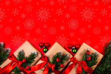 Christmas gifts in craft paper on a red background. Top view with copy space. Celebrating Christmas and New Years