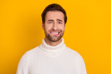 Photo of nervous horrified guy bite lip anticipate problems wear white knitted sweater isolated yellow color background