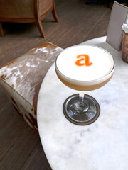 Fototapeta na wymiar Fresh cocktail glass with orange letter A in restaurant