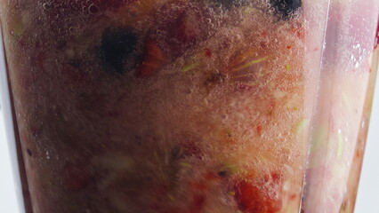 Fototapeta premium Closeup rotation blending fruits berries inside blender in super slow motion.