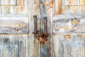 Old wooden door with rusty metal padlock