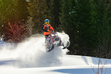 snowmobile fun. sports snow bike with snow splashes and snow trail. bright snowmobile and suit without brands. snowmobilers sports riding. stock photo very high quality - obrazy, fototapety, plakaty