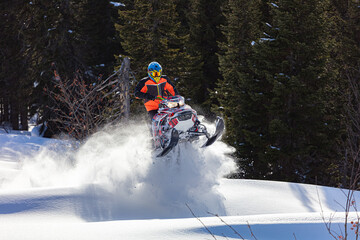 snowmobile fun. sports snow bike with snow splashes and snow trail. bright snowmobile and suit without brands. snowmobilers sports riding. stock photo very high quality - obrazy, fototapety, plakaty