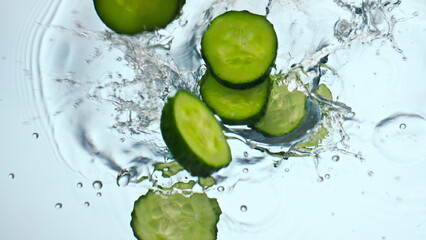 Cucumber slices splashing water in super slow motion close up. Vegetable falling