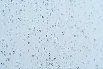 Raindrops on a window on a rainy day - rain concept, textures and patterns