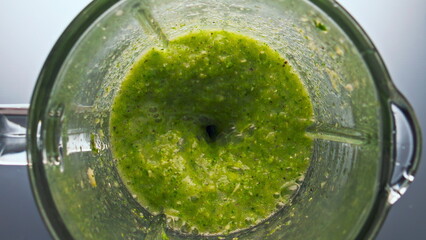 Top view blend vegetables swirling inside blender in super slow motion close up.