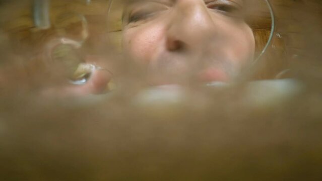 Man drinking beer or water . Beer pouring into mouth . Camera inside of beer glass or cup . Very funny angle view of camera . Close up