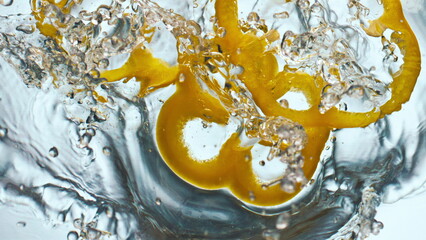 Yellow pepper splashing water in super slow motion close up. Vitamin vegetable.