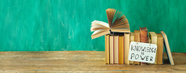 Open book, hardback books with knowledge is power sign on teal background.,education,reading....