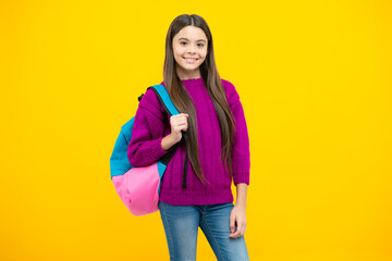 Schoolgirl in school uniform with backpack. Teenage girl student on yellow isolated background. Learning and education children.