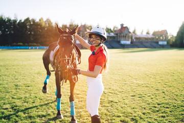 Happy female jockey with horse in countryside