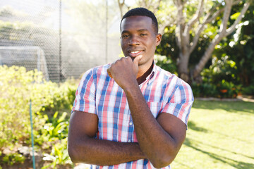 Obraz premium Portrait of happy african american man standing in sunny garden smiling