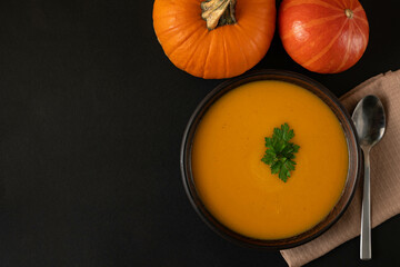 Pumpkin soup in a bowl on a dark background.