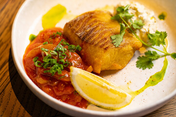 grilled pike perch on a white plate in a restaurant