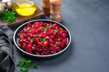 Salad vinaigrette with beetroot, vegetables, peas and sauerkraut on a dark background. Side view, horizontal