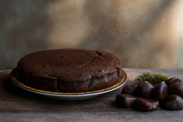 chestnut cake on wooden table with chestnuts nearby                                