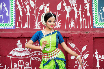 Odissi Dancer posing in front of wall. Culture of odisha.