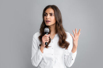 Beautiful business woman is speaking on conference. Young business woman talking with mic. Woman talking with microphone. Communication and information concept. - Powered by Adobe