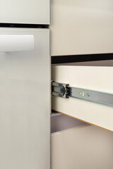 Roller stainless guide or rail for drawers with a closer. Close-up on a white background.