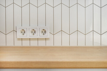View of kitchen wood countertop and white chevron tiles. Built-in socket. Minimalistic Scandinavian...