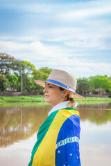 Woman wrapped in a brazilian flag wearing hat and jeans. Agribusiness woman.
