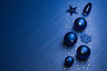 Classic blue Christmas decoration on a classic blue stone background with copy space. Golden stars....