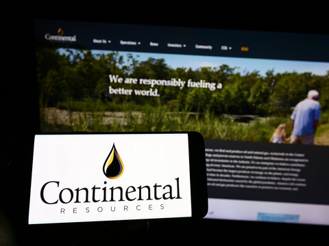 Stuttgart, Germany - 10-03-2022: Person holding cellphone with logo of US petroleum company Continental Resources Inc. on screen in front of webpage. Focus on phone display.