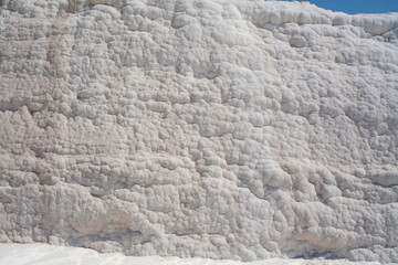 Background of natural white wall Pamukkale calcium travertine in Turkey, asymmetric pattern close-up. White cotton castle texture. Calcium stone textured