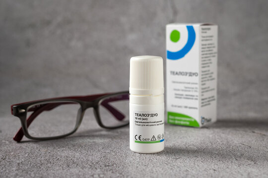 Rivne, Ukraine - June 25, 2022 - Thealoz Duo Othea ophthalmic solution, glasses, on a gray background
