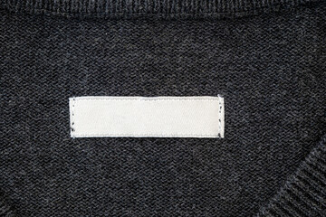 Blank stripe, label for branding on sweater. Tag mockup on gray cloth, top view.