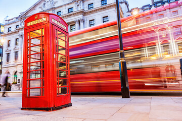 London red telephone booth and red bus in motion