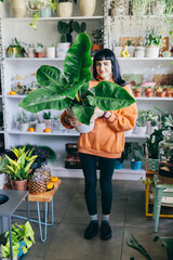 Woman with big green plant in florist shop
