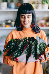Woman with green plant in florist shop.