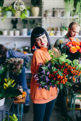 Woman working with florists in flower store