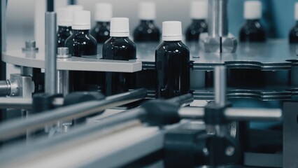 Automated production line conveyor in a factory with screw caps on glass bottles. Medical Conveyor Production of Pharmaceuticals. Twist Bottles. Pharmaceutical Industry. Close up, DOF