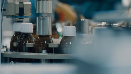 Automated production line conveyor in a factory with screw caps on glass bottles. Medical Conveyor Production of Pharmaceuticals. Twist Bottles. Pharmaceutical Industry. Close up, DOF