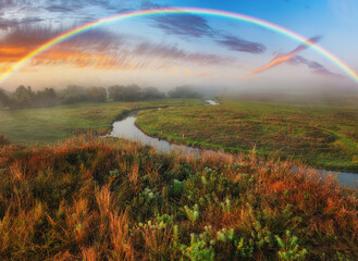 Amazing rainbow over the small rural river. autumn morning. nature of Ukraine
