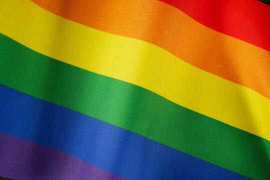 Rainbow flag as LGBT gay symbol background, closeup, top view