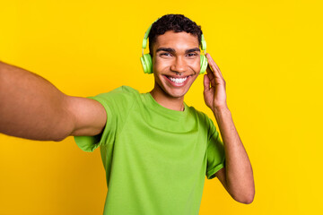 Photo portrait of nice young guy touch earphones take selfie front camera dressed trendy green look...