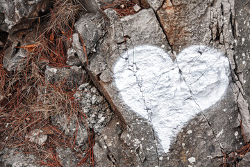 White heart drawn on the rock . Love symbol 