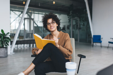 Millennial woman writing in notebook in office
