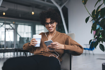 Woman listening music in earphones on smartphone
