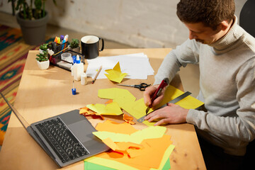 Making paper animal. Young man holds a master class on origami and recording vlog at home studio. Hobbies and leisure activities. Remote training, online classes