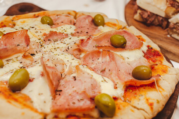 Primer plano de pizza de panceta, mozzarella y aceitunas.