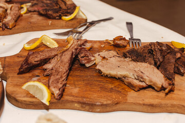Carne vacuna de ternera, asada con limón servida en tabla de madera. 