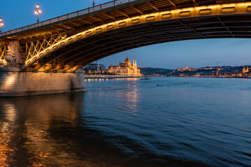 Danube river and Budapest Parliament under the bridge at night