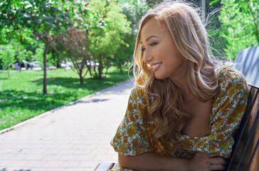 Naklejka premium Happy blond woman relaxing in a public park