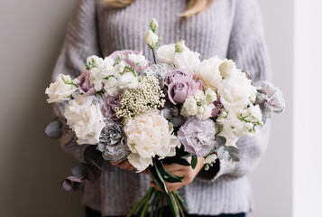 Very nice young woman holding big and beautiful bouquet of fresh roses, carnations, matthiola, eustoma flowers in pastel white and purple colors, cropped photo, bouquet close up - 538087071