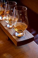 Flight of single malt scotch whisky in glasses served in whiskey bar in Edinburgh, UK